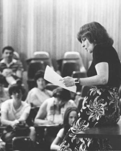Black and white photo of Alison Lurie teaching in 1977.