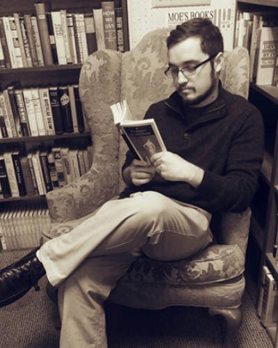 Peter Shipman reading in an armchair