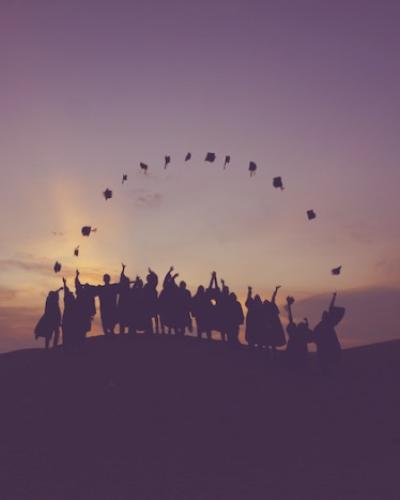 Silhouette of grads throwing caps